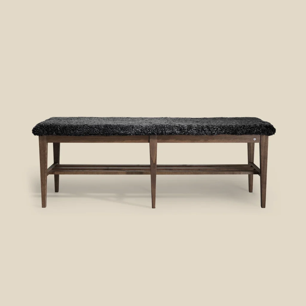 Nadja bench 130 in brown oiled ash with dark grey sheepskin on beige background
