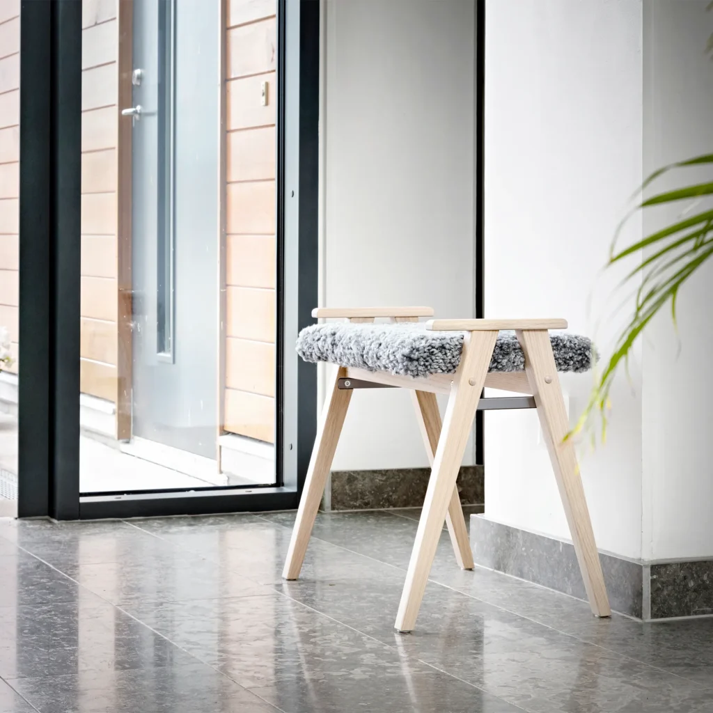Alme stool white oiled oak with light grey sheepskin in hallway